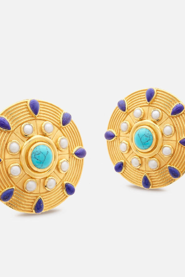 Pair of gold earrings with blue and white accents on a light gray background