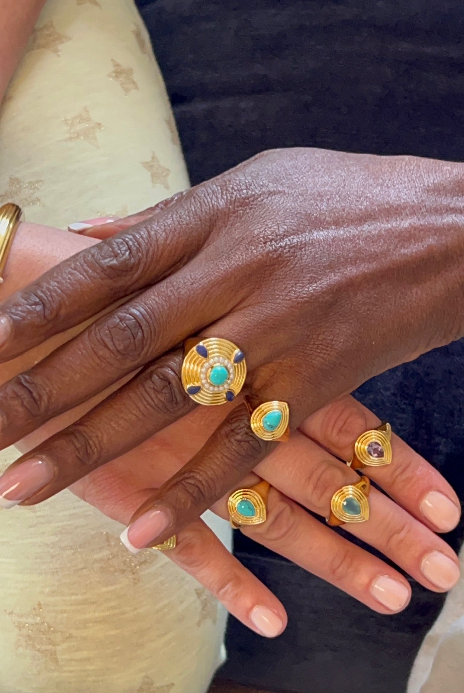 Hands wearing stackable gold plated rings