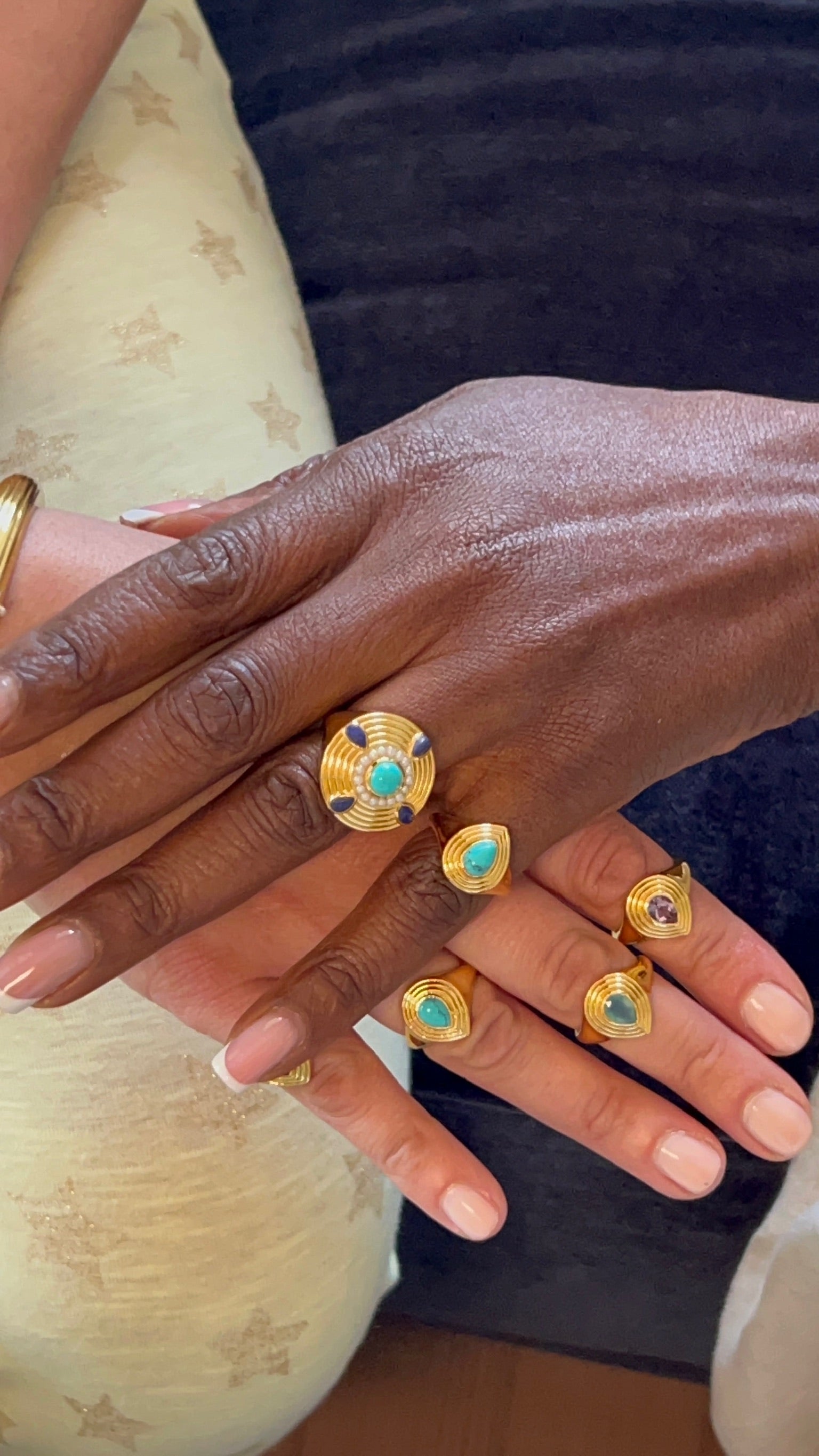 Hands wearing stackable gold plated rings