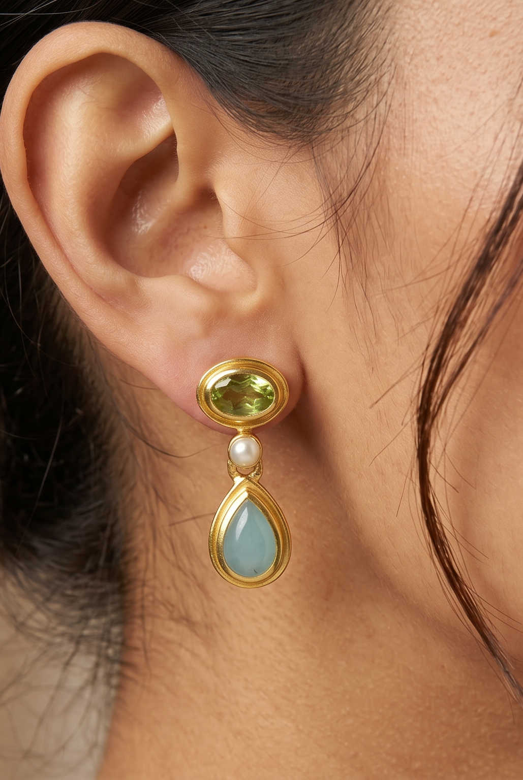 AI Image: Close-up of a woman wearing a gold drop earring with pearl, green and light blue gemstones