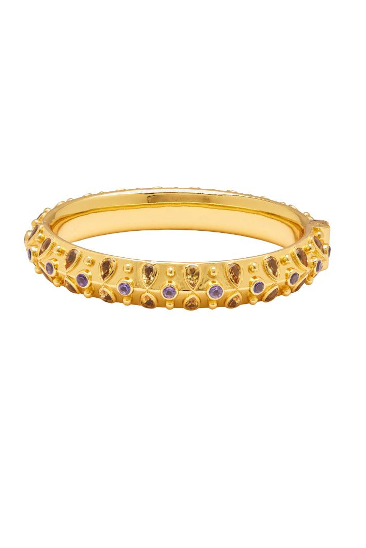 Gold bangle with embedded purple and yellow stones on a white background
