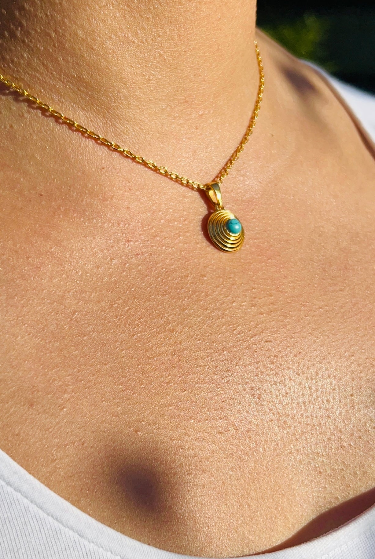 model wearing gold plated and turquoise pendant necklace