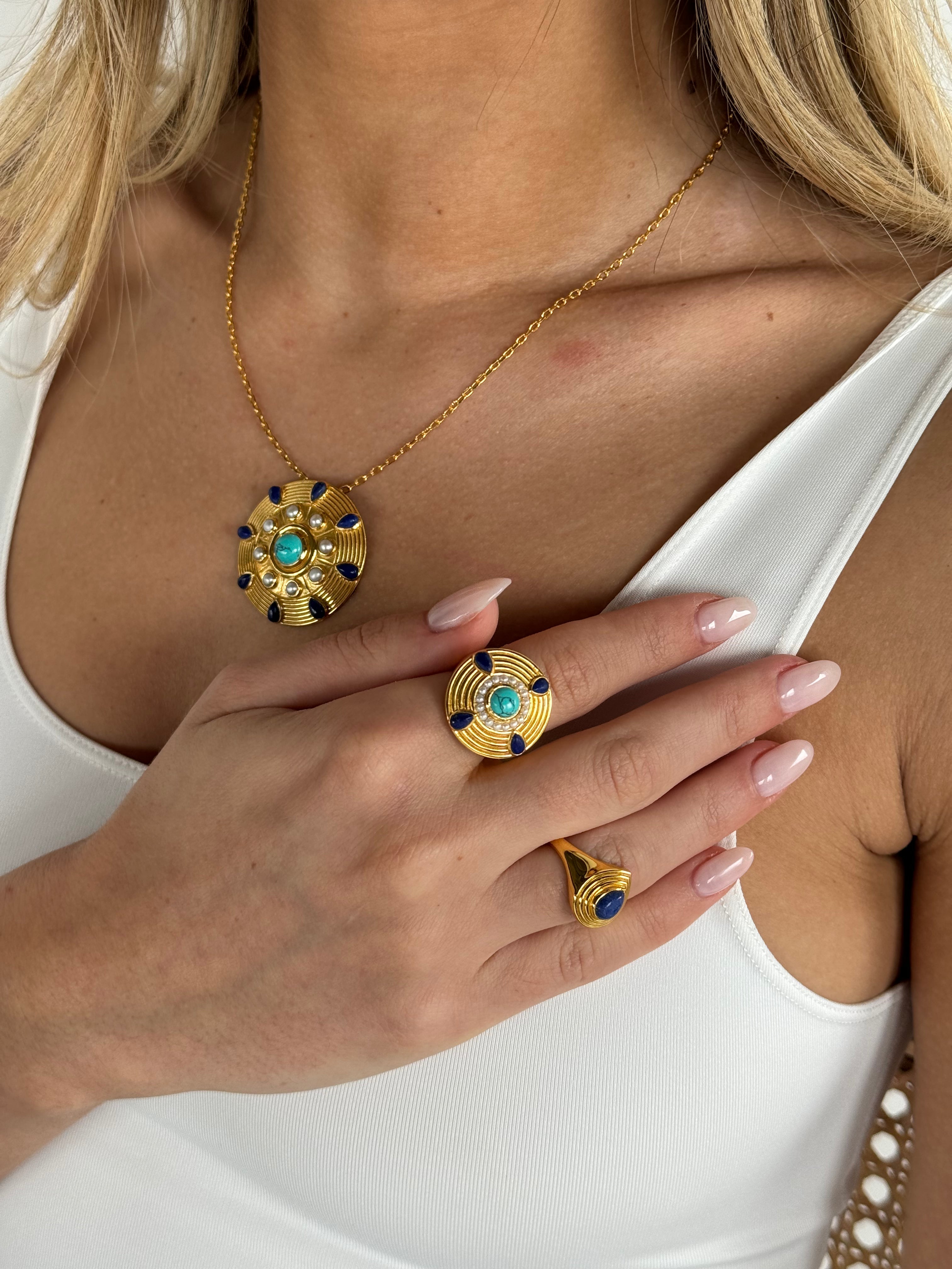 Hands and wrists showing Nila stacked turquoise and gold bangles and rings