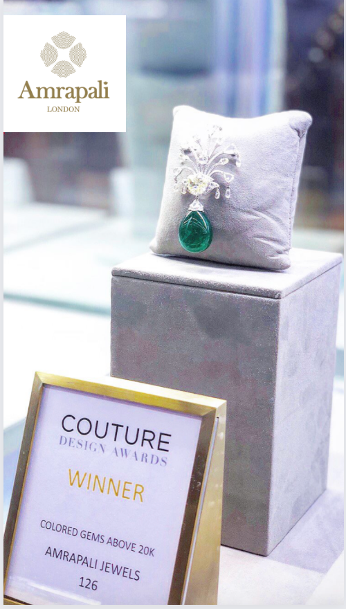 Amrapali Jewel's Emperor’s Garden Brooch with a 50-carat emerald bead drop on a plinth with it's Couture Design Awards Winner plaque