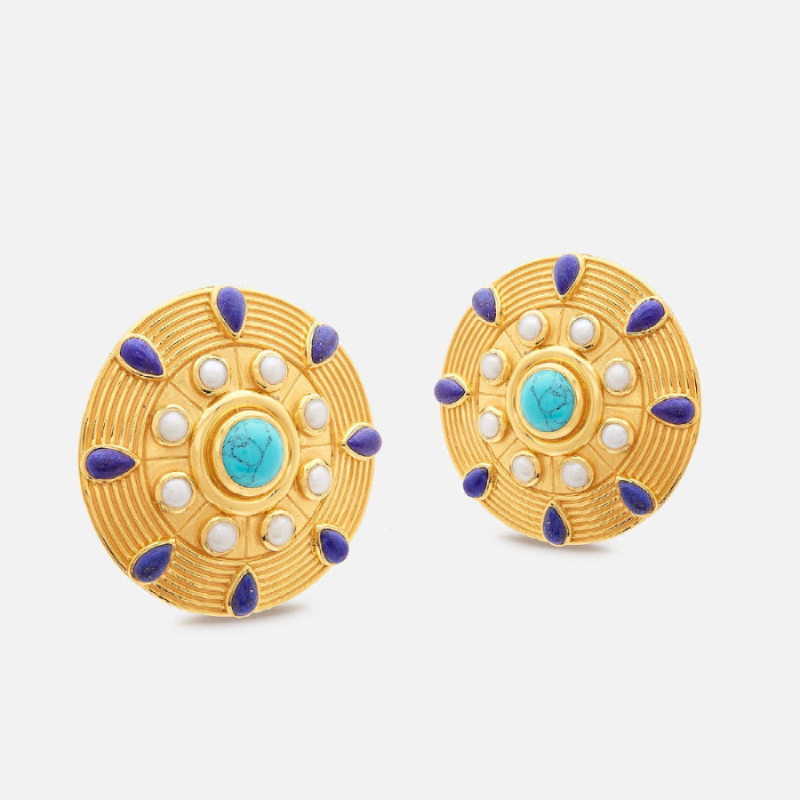 Pair of gold earrings with blue and white accents on a light gray background