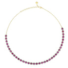Gold necklace with pink gemstones on a white background