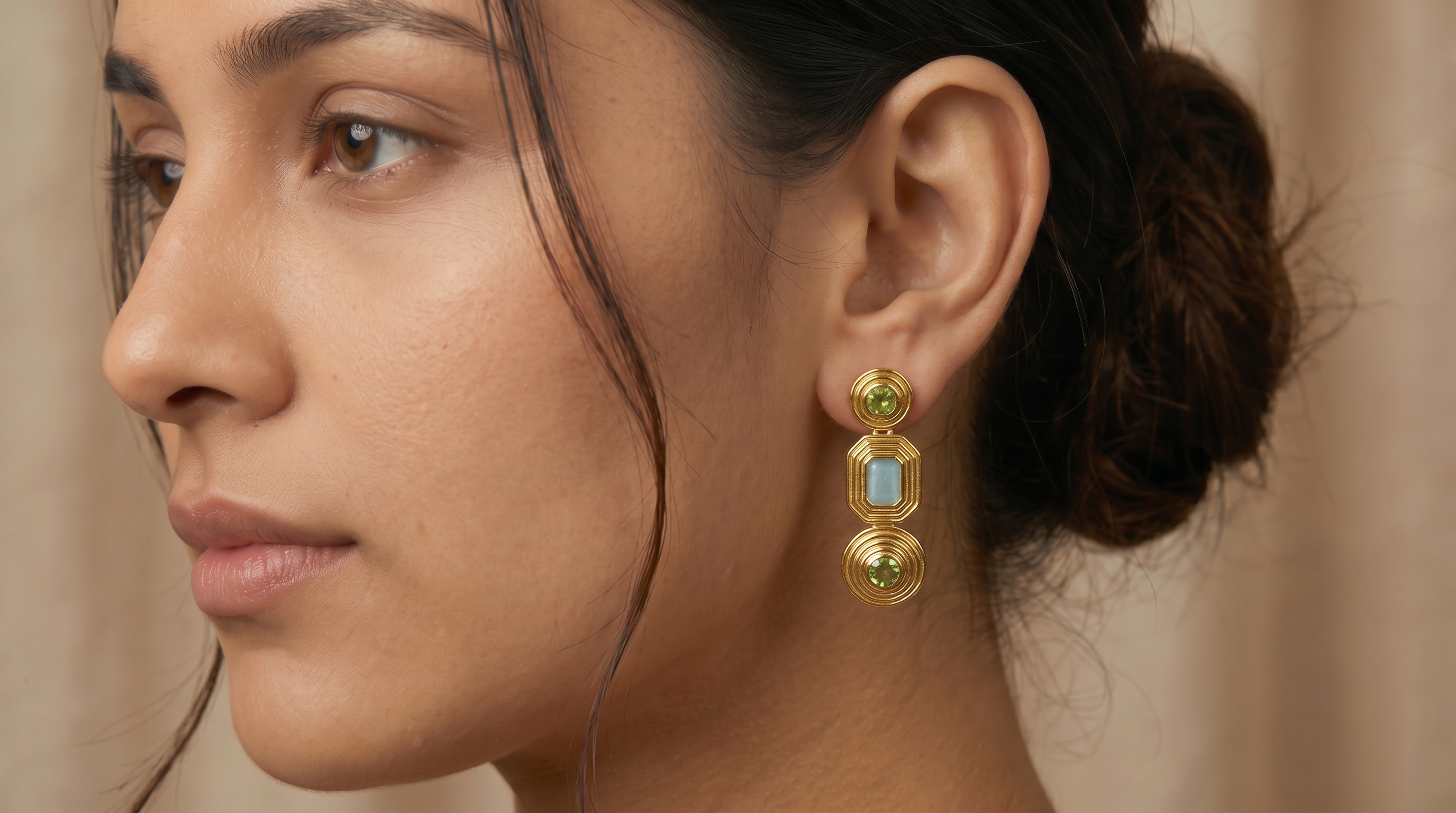AI Image: Close-up of a woman wearing gold cascade earrings with green and light blue gemstones against a neutral background