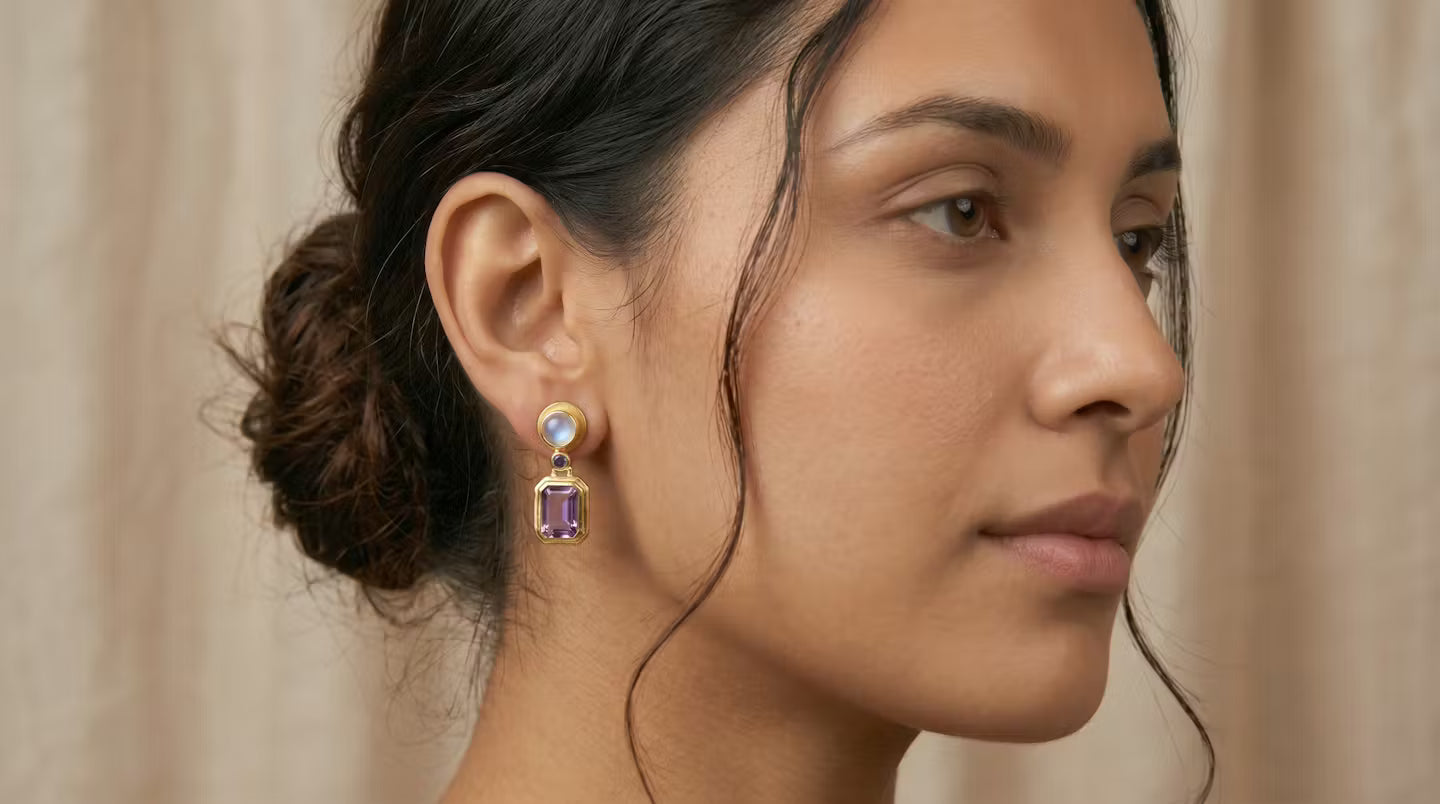 AI Image: Close-up of a woman wearing a pair of gold round and rectangular drop earrings with purple and opal gemstones on a beige background